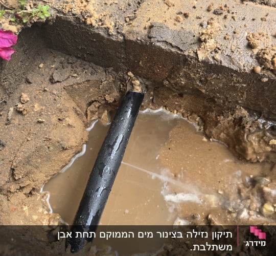 צינור מים שבור באדמה רטובה עם בוץ
